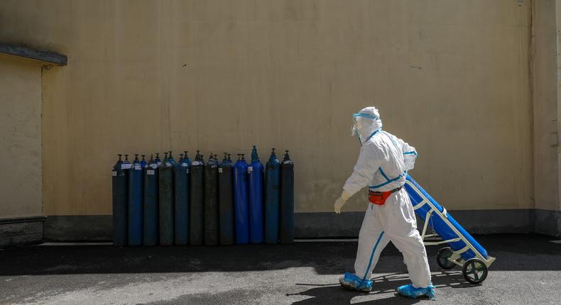 FILE PHOTO: A medical worker in protective suit transports an oxygen tank at Wuhan Red Cross Hospital in Wuhan, the epicentre of the novel coronavirus outbreak, in Hubei province, China February 16, 2020. Picture taken February 16, 2020. China Daily via REUTERS