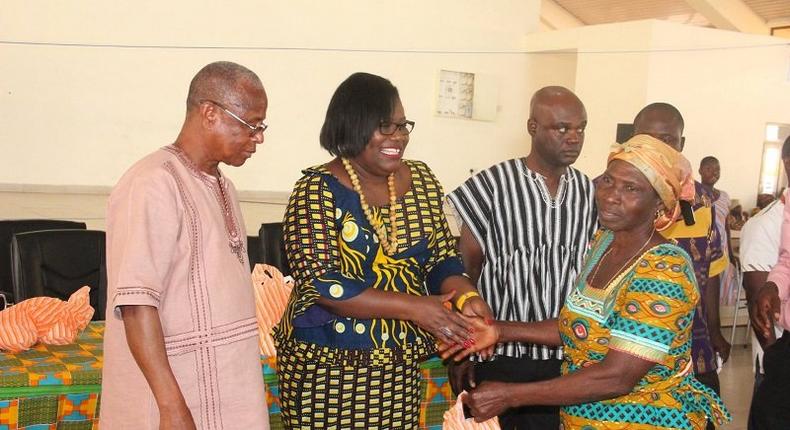  Nana Oye Lithur  presenting items and free NHIS card to an elderly woman