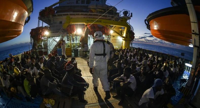 Migrants and refugees wait to be trasferred from the Topaz Responder ship in November 2016