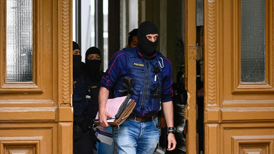 Funkcjonariusze policji wychodzą z materiałami zebranymi podczas przeszukania budynku, w którym działała grupa "Ostatnie Pokolenie", 24 maja 2023 r.