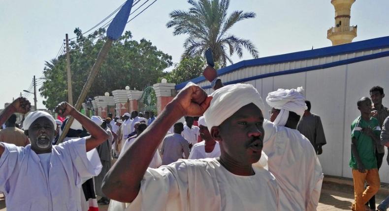 Sudanese men shout slogans during an anti-government protest following Friday noon prayers on January 18, 2019 outside a mosque in Khartoum's twin city Omdurman