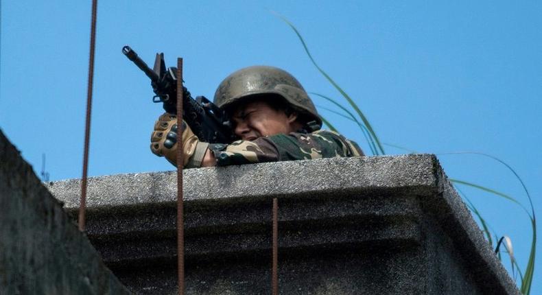 A Philippine soldier takes aim at militant positions from a rooftop in Marawi on June 13, 2017
