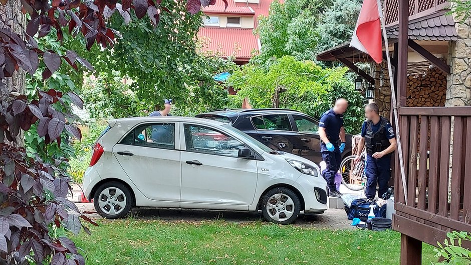 Policjanci przed domem, w którym znaleziono zwłoki małżeństwa