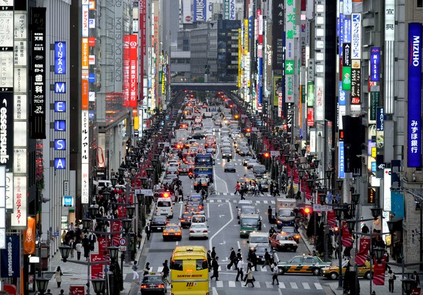 Główna ulica dzielnicy Ginza w Tokio zapełniona przechodniami.