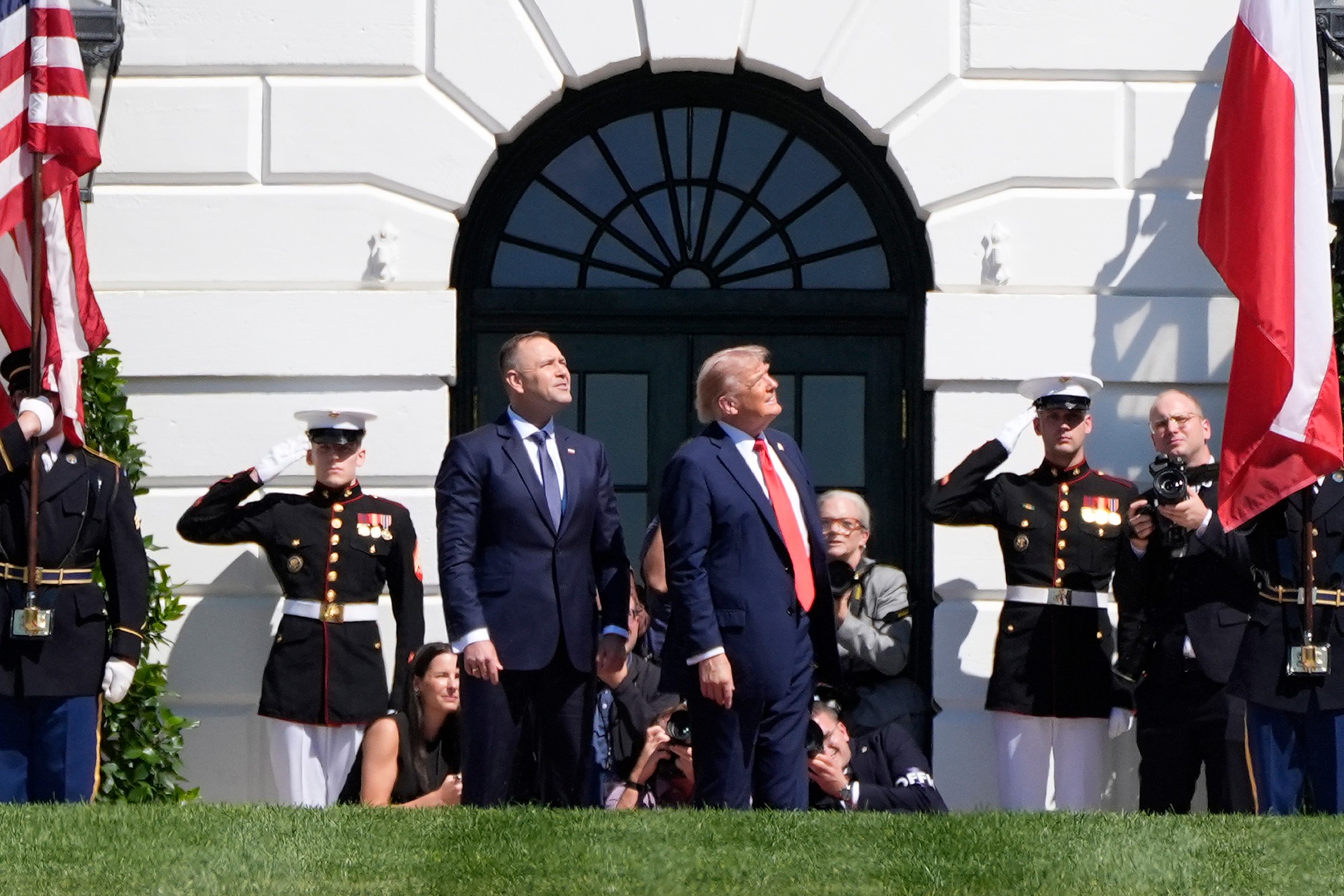 Poľský prezident Karol Nawrocki (v popredí vľavo) a prezident USA Donald Trump sledujú prelet vojenských lietadiel počas ich stretnutia pri Bielom dome vo Washingtone.
