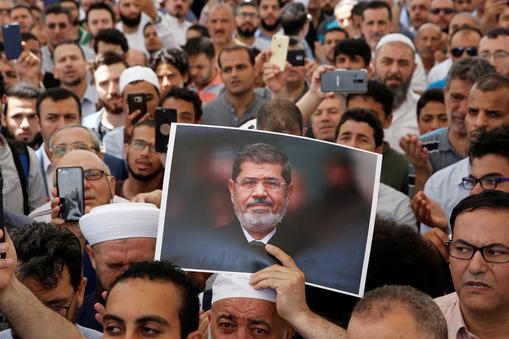 A man holds a picture of the former Egyptian president Mursi during a symbolic funeral prayer in Istanbul