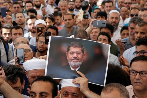 A man holds a picture of the former Egyptian president Mursi during a symbolic funeral prayer in Istanbul