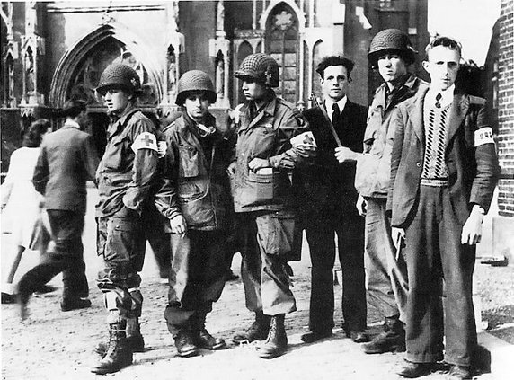 Żołnierze ze słynnej amerykańskiej 101 Dywizji Powietrzno-Desantowej sfotografowani wraz z członkami holenderskiego ruchu oporu (domena publiczna).