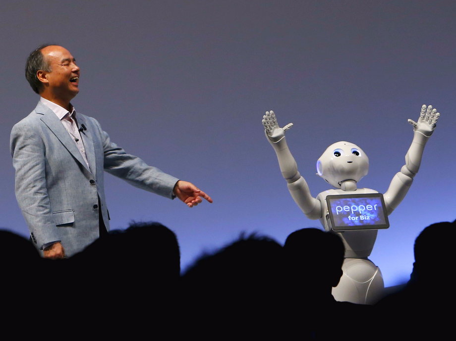 SoftBank CEO Masayoshi Son reacts as SoftBank's human-like robots named "Pepper" performs during the SoftBank World 2015 event in Tokyo, Japan.