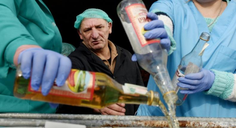 A supervisor looks on as workers empty bottles of the adulterated vodka in the town of Vynnyky, western Ukraine