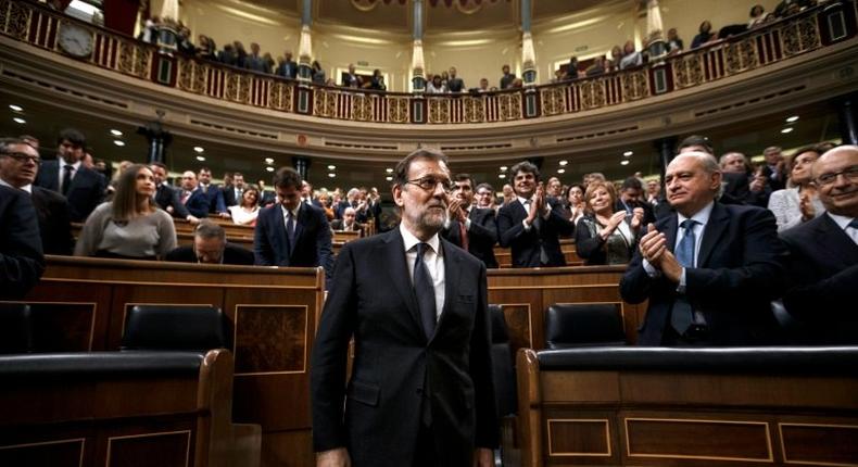 Newly-reelected Spanish Prime Minister Mariano Rajoy (C) kept Luis de Guindos as economy minister and Cristobal Montoro as finance minister