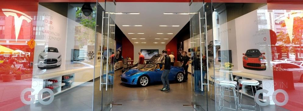 Klienci oglądają Model X Tesli w salonie Tesla Motors w San Jose w Kalifornii. Tesla Motors planuje sprzedaż Modelu X, sportowego samochodu zasilanego energią elektryczną, już w 2013 roku.