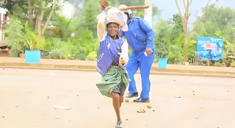 Viral photo of an elderly woman running past a police officer in Kisii during the Saba Saba protests (Courtesy)