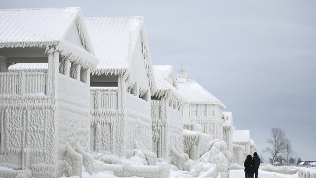 Fale zamieniły domy w gigantyczne lodowe rzeźby. 