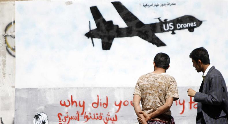 Men look at wall graffiti depicting a U.S. drone along a street in Sanaa, Yemen, November 9, 2013. 
