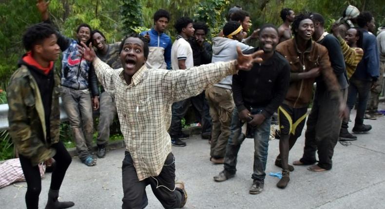 Migrants celebrate after forcing their way through a fence between Morocco and the tiny Spanish enclave of Ceuta, on February 17, 2017