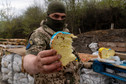 Żołnierz trzyma wielkanocny wypiek w punkcie kontrolnym w Charkowie