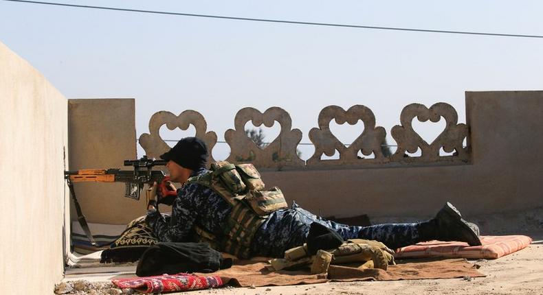 A sniper from Iraq's Federal Police force takes aim at ISIS positions from the roof of a house on the frontline in Albu Saif, south of Mosul.