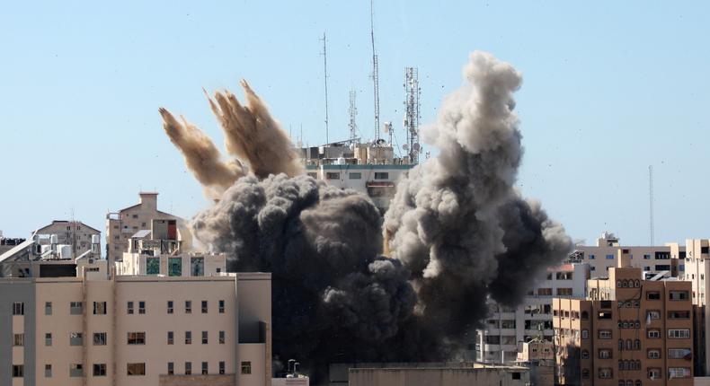 A thick column of smoke rises from the Jala Tower as it is destroyed in an Israeli airstrike in Gaza city controlled by the Palestinian Hamas movement, on May 15, 2021
