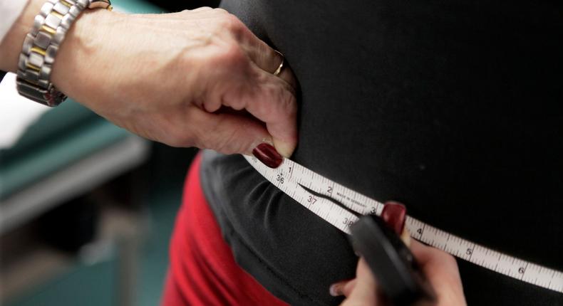 FILE - A subject's waist is measured during an obesity prevention study 