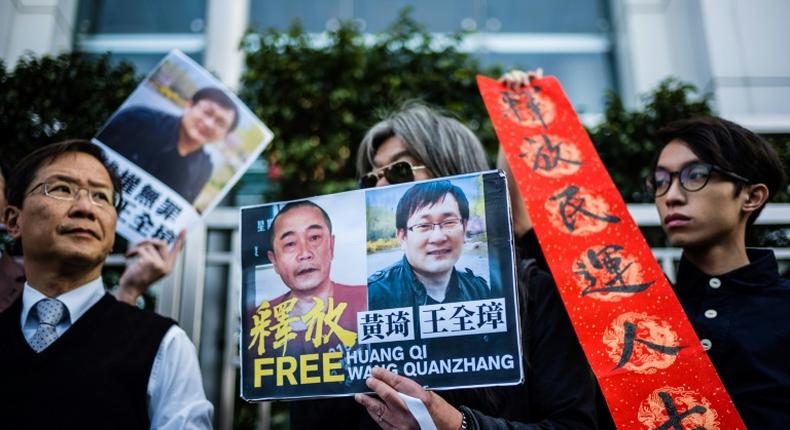 Hong Kong pro-democracy activists attend a protest in support of jailed Chinese human rights lawyer Wang Quanzhang (R on placard) and China's first cyber-dissident and founder of human rights website 64 Tianwang, Huang Qi (L on placard)