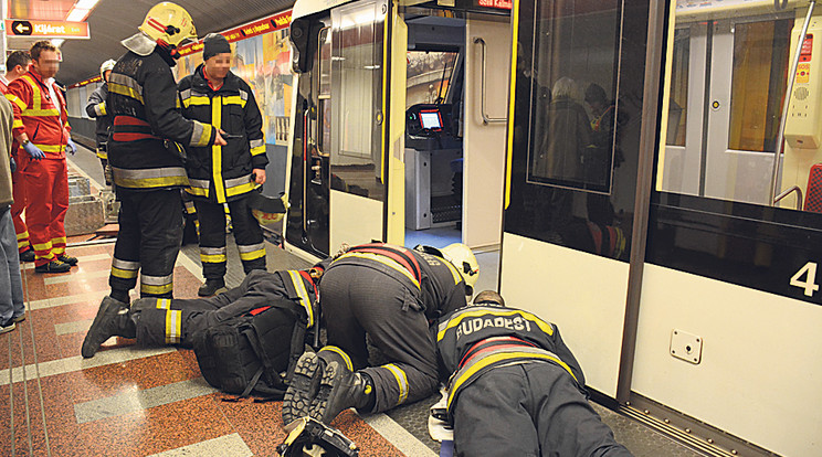Az állomásra érkező tűzoltók megfeszített munkával emelték ki a peronra a sínek közé bezuhanó asszonyt /Fotó: Schultz László