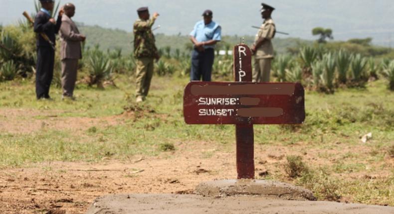 Kenyan police near a grave