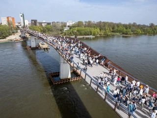 „Trwa szaleństwo związane z odwiedzaniem i przechadzaniem się przez nową kładkę pieszo-rowerową przerzuconą przez Wisłę, która ostatecznie kosztowała ok. 154 mln zł – wobec planowanych pierwotnie 121 mln zł”.