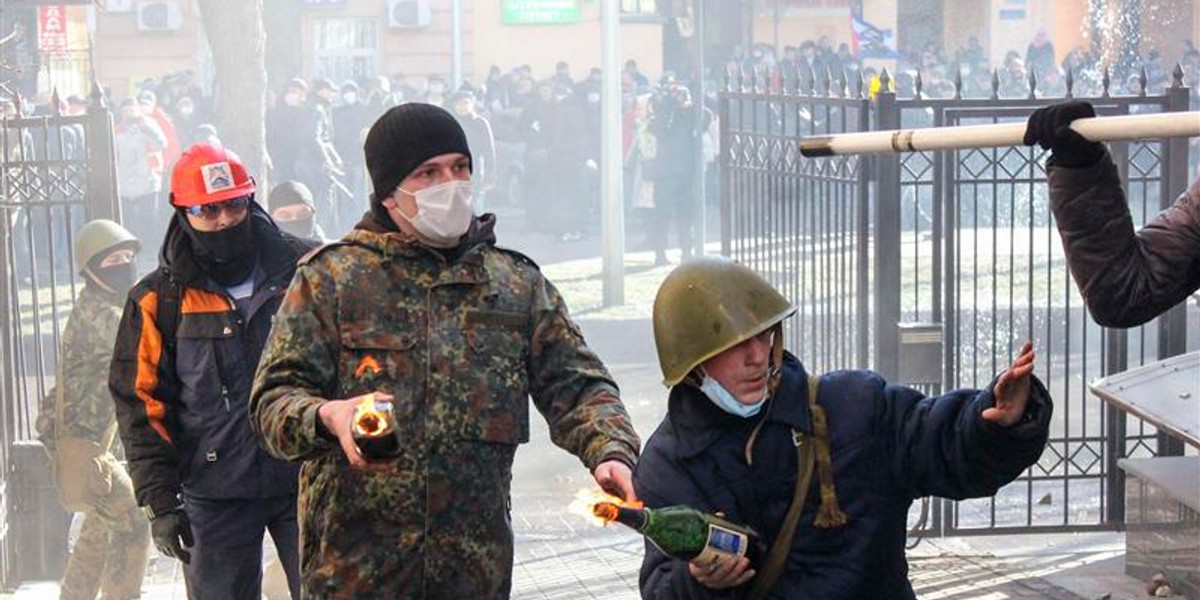 Antigovernment protesters hold Molotov cocktails as they attack an office of the pro-presidential Party of the Regions in Kiev.