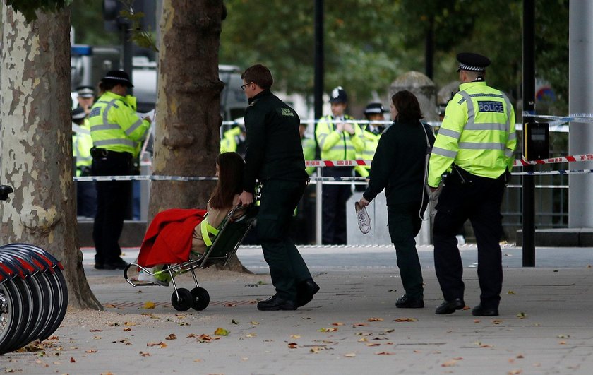 Emergency services personnel wheel a woman in a wheelchair to a nearby ambulance near the Natural Hi