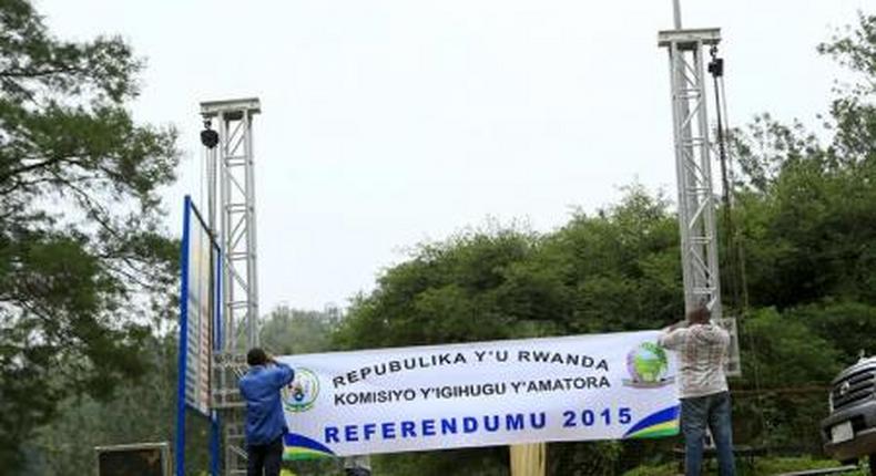 People erect a banner at the entrance of a polling station on the eve of a referendum as Rwandans will vote to amend its Constitution to allow President Paul Kagame to seek a third term in Rwanda capital Kigali, December 17, 2015.