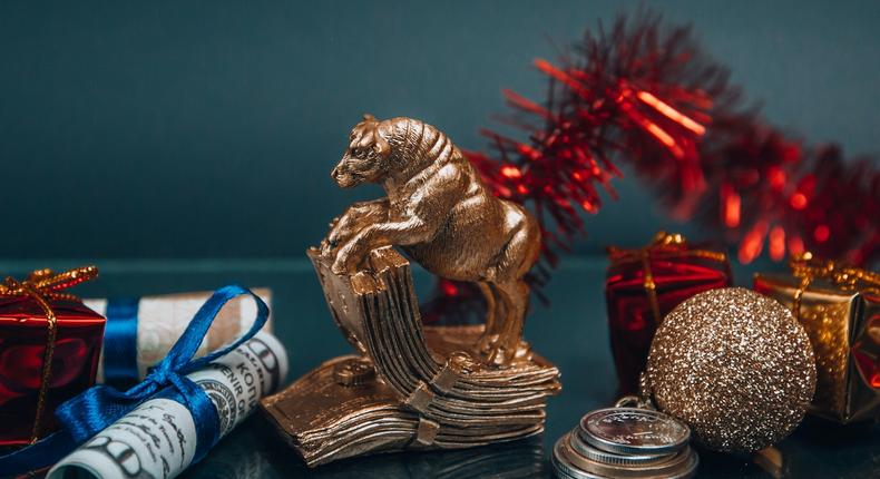 Shiny golden bull figurine and bauble arranged with money during New Year holiday (Photo: Victoria Emerson)