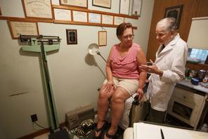 Dr. Bryon Harbolt examines patient Barbara Kilgore in his Cathedral Canyon Clinic in Altamont