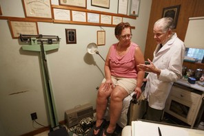 Dr. Bryon Harbolt examines patient Barbara Kilgore in his Cathedral Canyon Clinic in Altamont