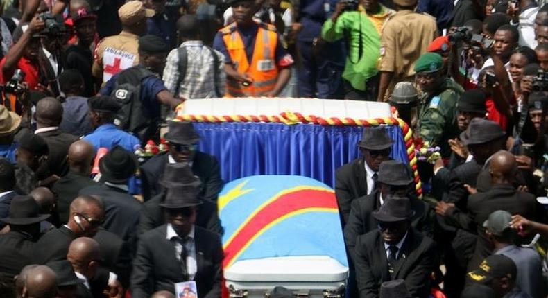 A general view taken through a window shows mourners escorting the casket of legendary Congolese singer Papa Wemba, born Jules Shungu Wembadio Pene Kikumba, from the the Notre Dame du Congo Cathedral for burial, along the streets of the Democratic Republic of Congo's capital Kinshasa, May 4, 2016. 