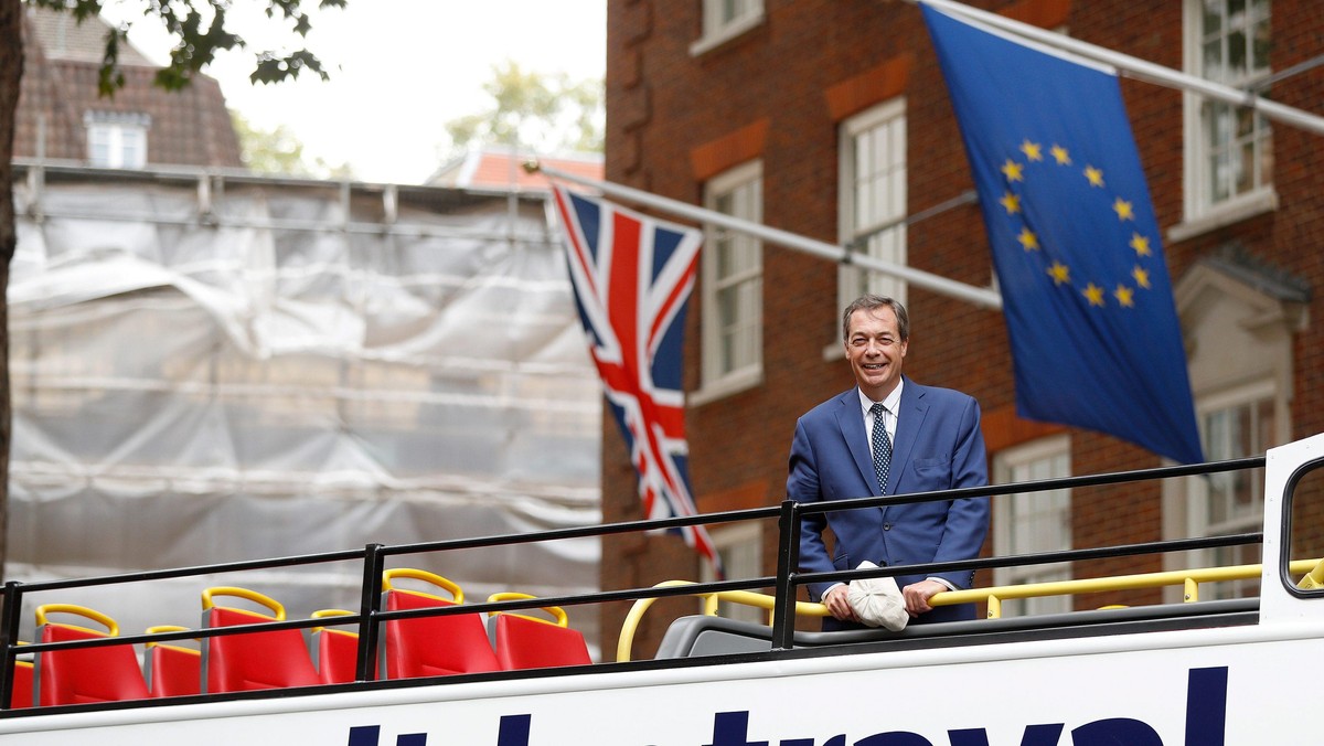 Nigel Farage passes a European Union flag as he rides a bus while campaigning against Britain's Prim