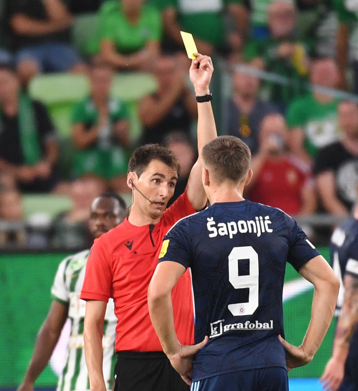 Hlavný rozhodca Ricardo de Burgos zo Španielska udeľuje žltú kartu hráčovi Slovana Ivanovi Šaponjičovi.