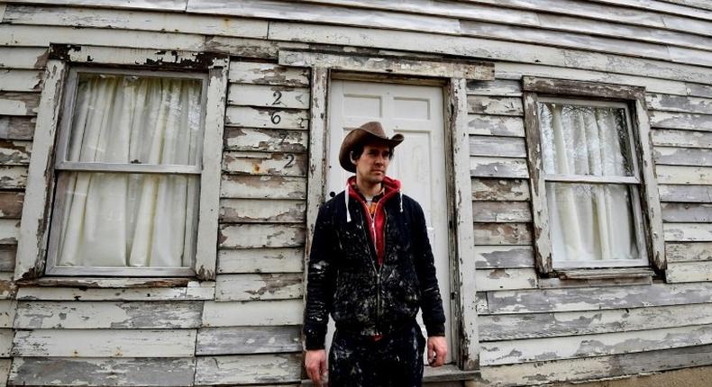 Artist Ryan Mendoza poses in front of Rosa Parks' house during which he helped rescue from Detroit and rebuilt it in his garden