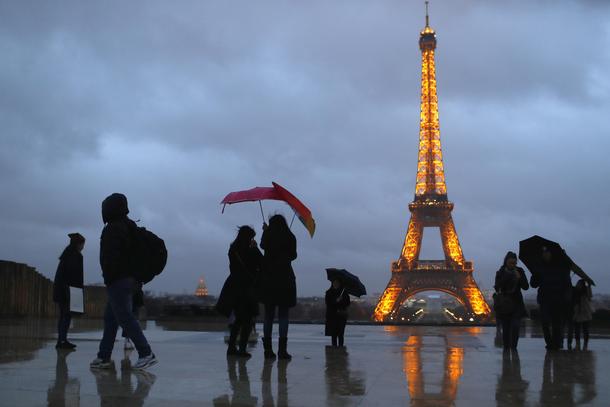 People protect themselves from the rain under umbrellas at Trocadero square near the Eiffel Tower in