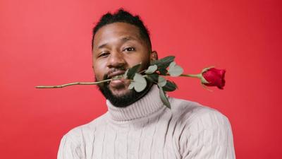 Man in white turtleneck sweater holding red rose [Image Credit: RDNE Stock Project]
