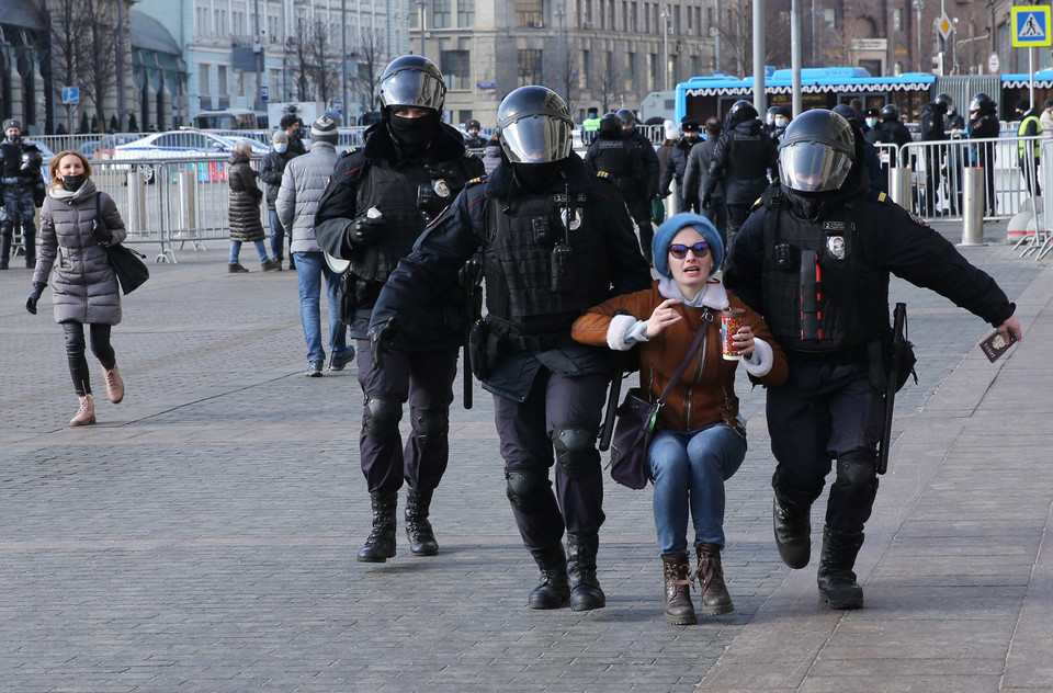 Policjanci zatrzymują kobietę podczas niesankcjonowanego wiecu protestacyjnego na placu Maneżnaja przed Kremlem