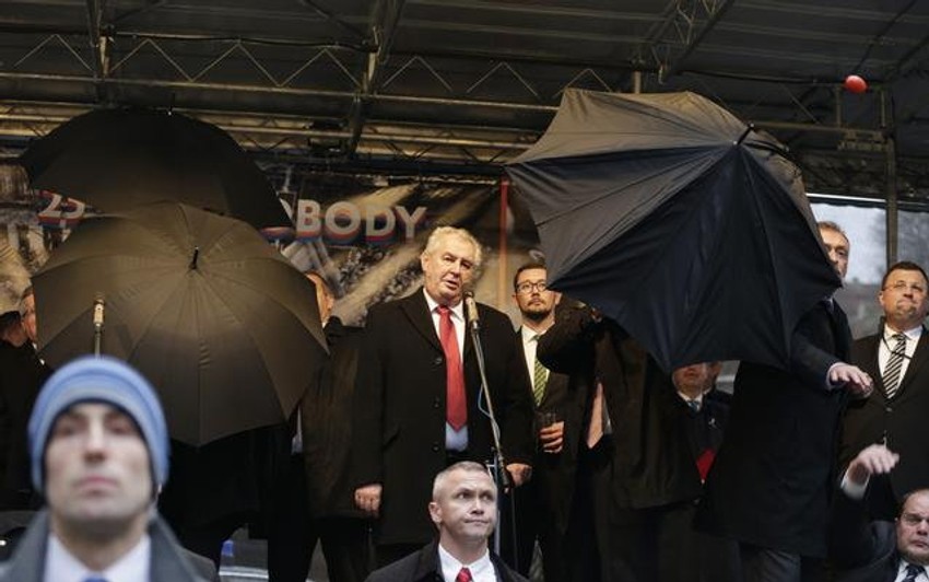 Miloš Zeman drži govor iza kišobrana