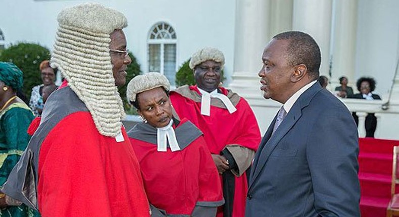 President Uhuru Kenyatta chats with Chief Justice David Maraga after the swearing-in of new judges of the High Court at State House, Nairobi. 