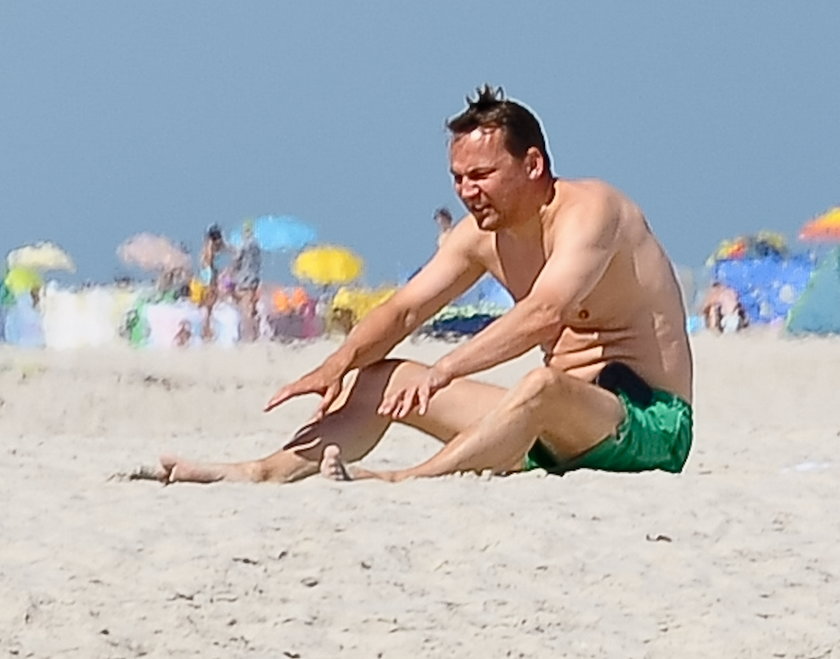 Radosław Sikorski na plaży ćwiczy brzuszki 