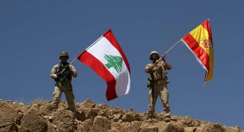 A handout picture released by the Lebanese army on August 19, 2017, shows Lebanese soldiers holding up the Lebanese and Spanish flags in Jurud Ras Baalbek, in solidarity with Spain after twin attacks claimed by the Islamic State group