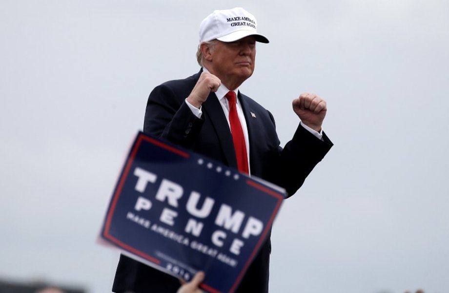 Trump reacting to cheers from supporters while leaving a campaign rally.