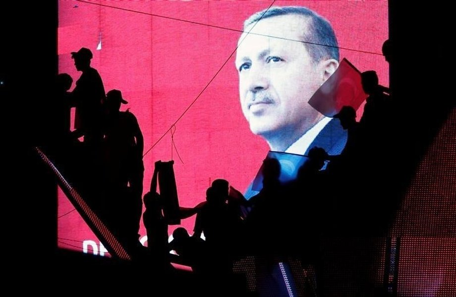 Turkish Supporters are silhouetted against a screen showing President Tayyip Erdogan during a pro-government demonstration in Ankara