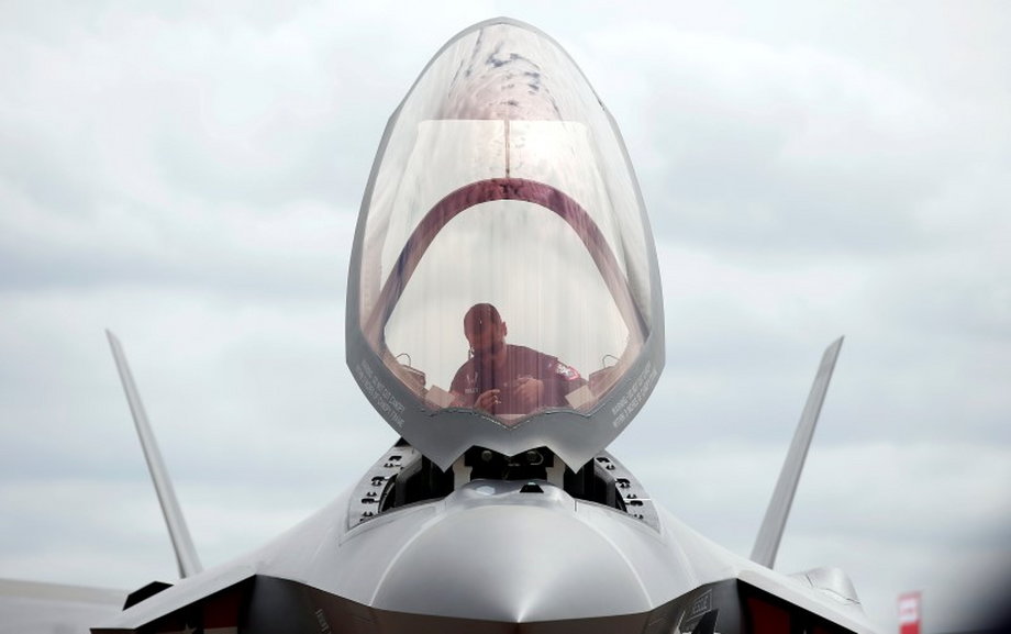 A ground crew member works in the cockpit of a US Marine Corps Lockheed Martin F-35B fighter jet at the Royal International Air Tattoo at Fairford