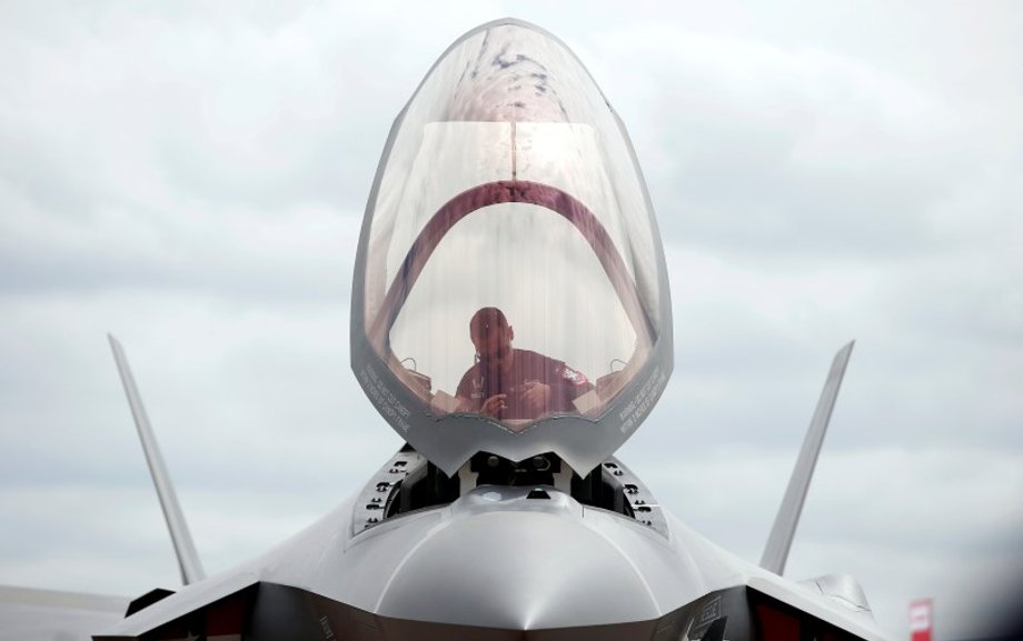 A ground crew member works in the cockpit of a US Marine Corps Lockheed Martin F-35B fighter jet at the Royal International Air Tattoo at Fairford