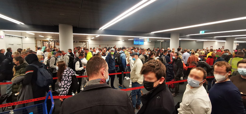 Tłum na warszawskim lotnisku we czwartek wieczorem czeka na wykonanie testu zwalniającego z kwarantanny